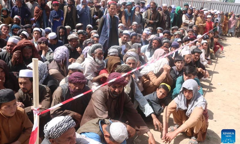 People wait to receive food aid from the Afghan Red Crescent Society in Kunduz, Afghanistan, April 14, 2022. About 1,000 destitute and drought-affected families received relief assistance in Afghanistan's northern province of Kunduz on Thursday, a provincial official said.(Photo: Xinhua)