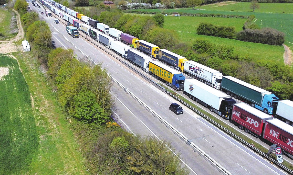 Cars pass trucks and heavy goods vehicles stuck in heavy traffic on the M20 road near Ashford to the port of Dover as Operation Brock is employed, in southeast England on April 15, 2022. Photo: AFP