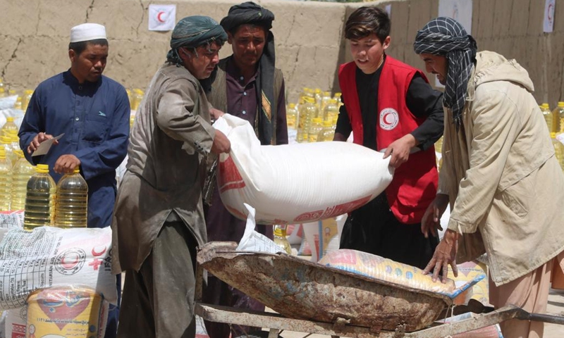 People receive food aid from the Afghan Red Crescent Society in Kunduz, Afghanistan, April 14, 2022. About 1,000 destitute and drought-affected families received relief assistance in Afghanistan's northern province of Kunduz on Thursday, a provincial official said. (Photo: Xinhua)