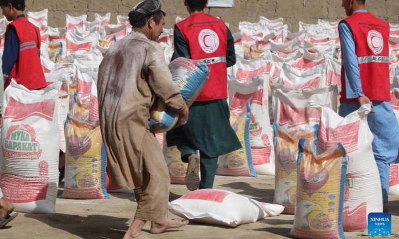 People receive food aid from the Afghan Red Crescent Society in Kunduz, Afghanistan, April 14, 2022. About 1,000 destitute and drought-affected families received relief assistance in Afghanistan's northern province of Kunduz on Thursday, a provincial official said.(Photo: Xinhua)