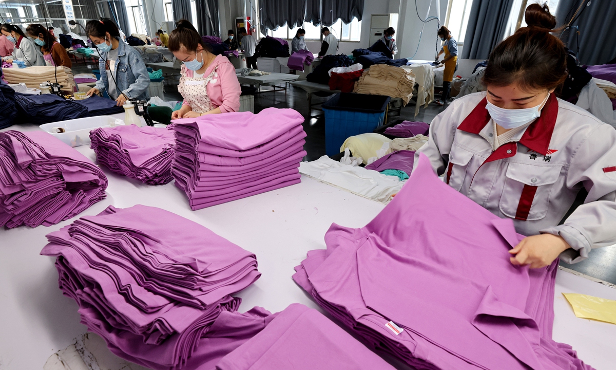 Workers sort garments for export markets in Zaozhuang, East China's Shandong Province on April 17, 2022. Chinese exporters need balance production and COVID-19 precautions. Official data showed thsat China's foreign trade totaled 9.42 trillion yuan ($1.48 trillion) in the first quarter of 2022, up 10.7 percent year-on-year. Photo: cnsphoto