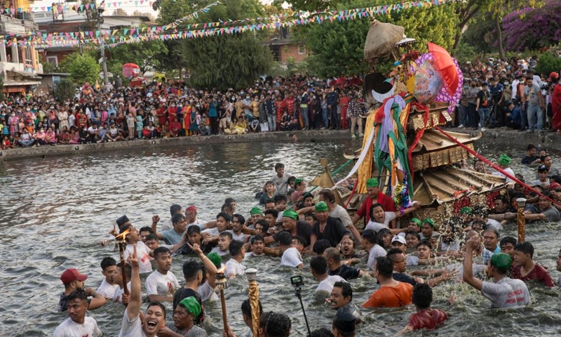 Local people carry the chariot of Tundaldevi on their shoulders and search for the lost jewellery during the traditional Gahana Khojne Jatra festival in Gahana Pokhari (Jewel-Pond) in Kathmandu, Nepal, April 17, 2022.Photo:Xinhua