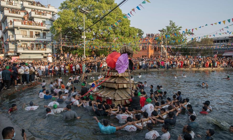 Local people carry the chariot of Tundaldevi on their shoulders and search for the lost jewellery during the traditional Gahana Khojne Jatra festival in Gahana Pokhari (Jewel-Pond) in Kathmandu, Nepal, April 17, 2022.Photo:Xinhua