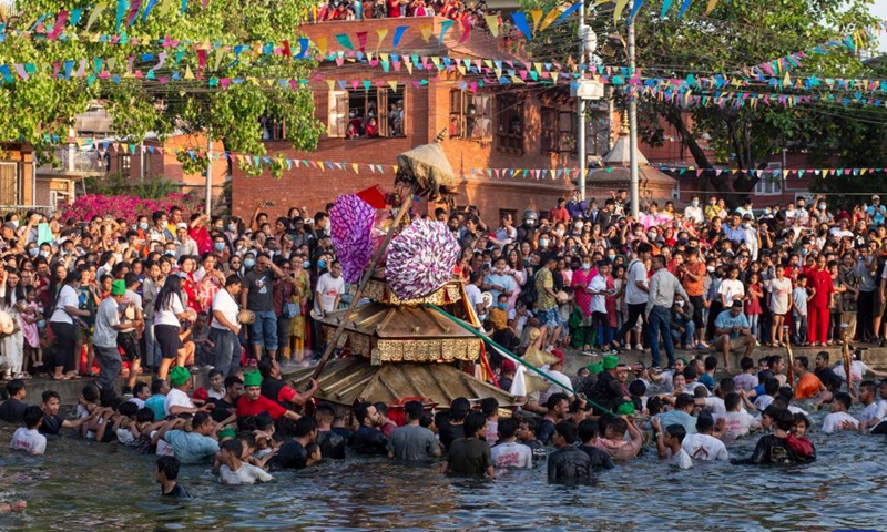 Local people carry the chariot of Tundaldevi on their shoulders and search for the lost jewellery during the traditional Gahana Khojne Jatra festival in Gahana Pokhari (Jewel-Pond) in Kathmandu, Nepal, April 17, 2022.Photo:Xinhua