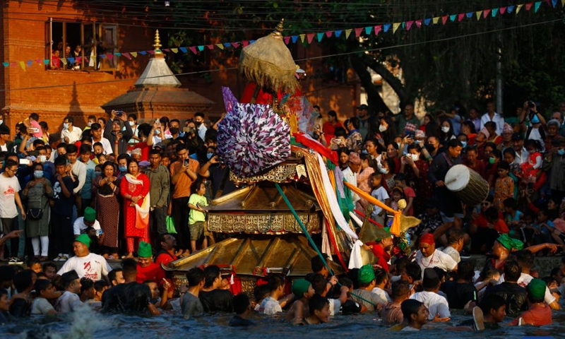 Local people carry the chariot of Tundaldevi on their shoulders and search for the lost jewellery during the traditional Gahana Khojne Jatra festival in Gahana Pokhari (Jewel-Pond) in Kathmandu, Nepal, April 17, 2022.Photo:Xinhua