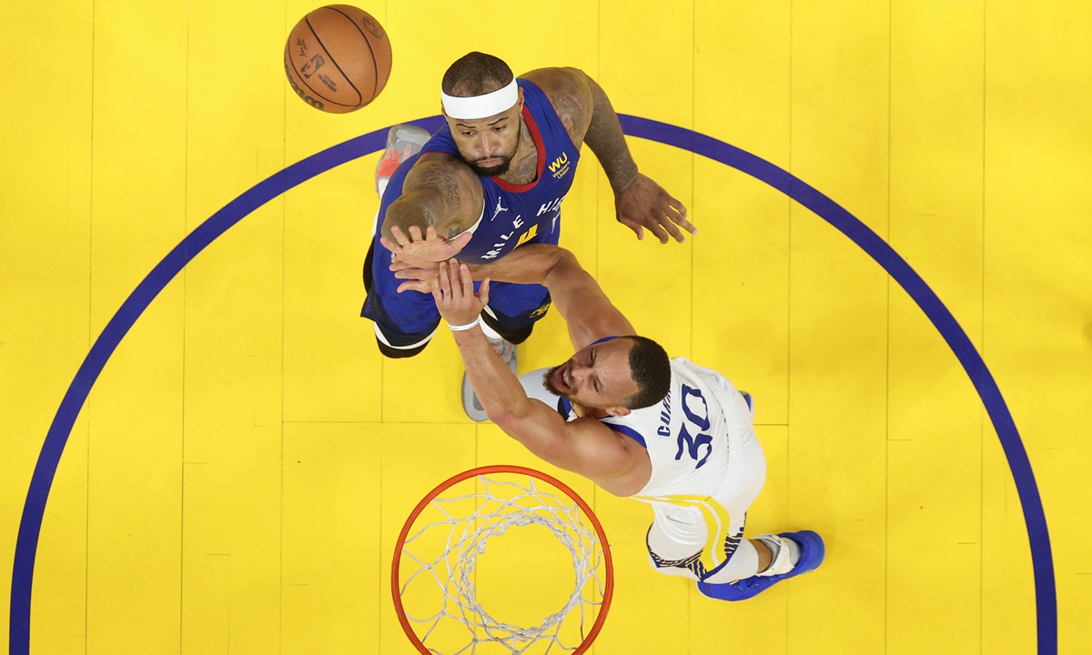 Stephen Curry (below) of the Warriors is fouled by DeMarcus Cousins of the Nuggets on April 18, 2022 in San Francisco, California. Photo: VCG