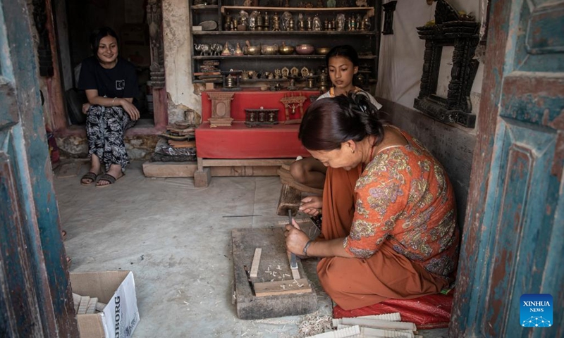 A woman works on wood carving in Bungamati, Lalitpur, Nepal, April 18, 2022.(Photo: Xinhua)