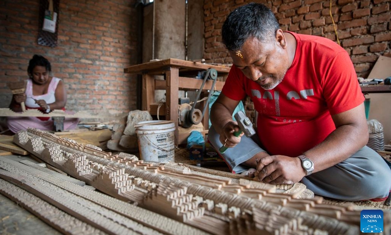 A man works on wood carving in Bungamati, Lalitpur, Nepal, April 18, 2022.(Photo: Xinhua)