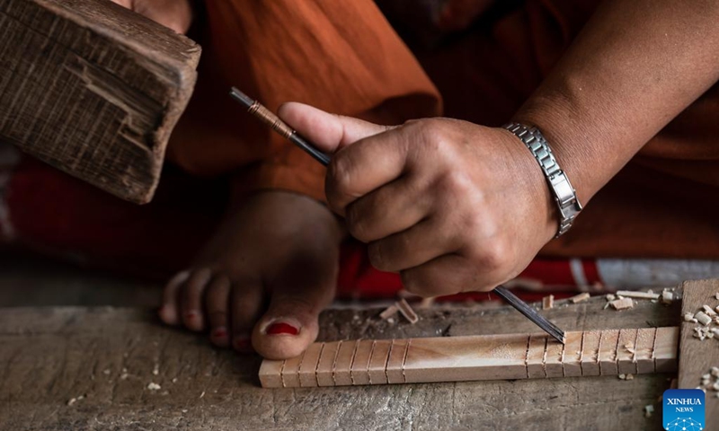 A woman works on wood carving in Bungamati, Lalitpur, Nepal, April 18, 2022.(Photo: Xinhua)