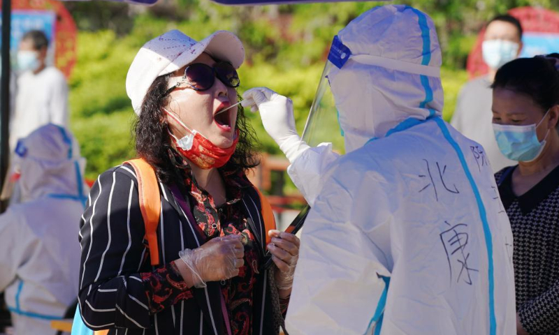 A medical worker takes a swab sample from a resident for a nucleic acid test in Shijingshan District, Beijing, capital of China, May 3, 2022. Beijing's 12 districts have started three rounds of nucleic acid screening from Tuesday till Thursday on a daily basis in succession to curb the COVID-19 resurgence. (Xinhua/Zhang Chenlin)