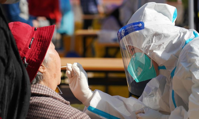 A medical worker takes a swab sample from a resident for a nucleic acid test in Shijingshan District, Beijing, capital of China, May 3, 2022. Beijing's 12 districts have started three rounds of nucleic acid screening from Tuesday till Thursday on a daily basis in succession to curb the COVID-19 resurgence. (Xinhua/Zhang Chenlin)