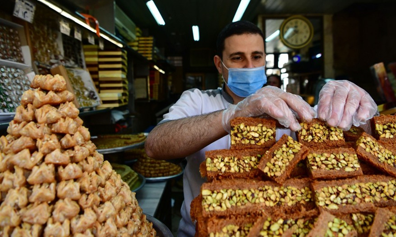 Syrian sweet maker is seen arranging sweets at the display of his shop in the capital Damascus on April 27, 2022.Photo:Xinhua