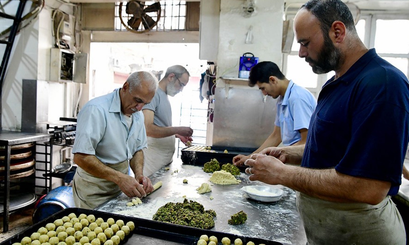 Syrian sweet makers are seen arranging sweets at the display of his shop in the capital Damascus on April 27, 2022.Photo:Xinhua