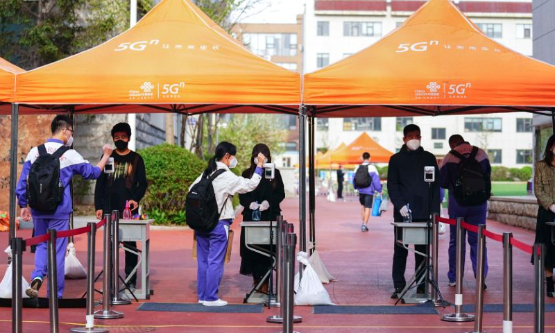 Third-graders of a senior high school take their temperatures to enter the school in Changchun, northeast China's Jilin Province, May 5, 2022. Third-graders of senior high schools in Changchun resumed class on Thursday. (Xinhua)