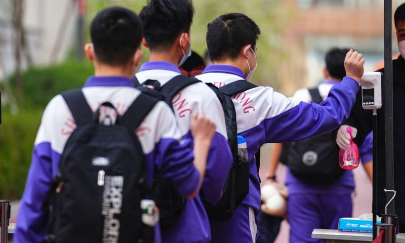 Third-graders of a senior high school take their temperatures to enter the school in Changchun, northeast China's Jilin Province, May 5, 2022. Third-graders of senior high schools in Changchun resumed class on Thursday. (Xinhua)