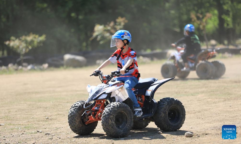 A boy drives a kart at a scenic area in Hangzhou, east China's Zhejiang Province, on May 3, 2022, the fourth day of the Labor Day holiday.Photo:Xinhua