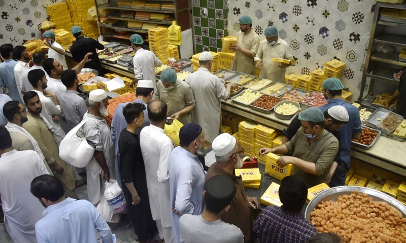 People buy traditional sweets during the Eid al-Fitr holiday in northwest Pakistan's Peshawar on May 2, 2022.Photo:Xinhua