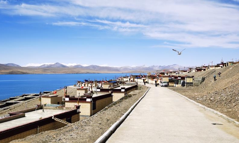 Cellphone photo taken on May 1, 2022 shows a road and Tibetan-style houses in Tuiwa Village, Nagarze County in Shannan, southwest China's Tibet Autonomous Region. With an altitude of 5,070 meters, Tuiwa Village is located at the foot of the Mongda Kangri Mountain and by the Puma Yumco Lake.(Photo: Xinhua)