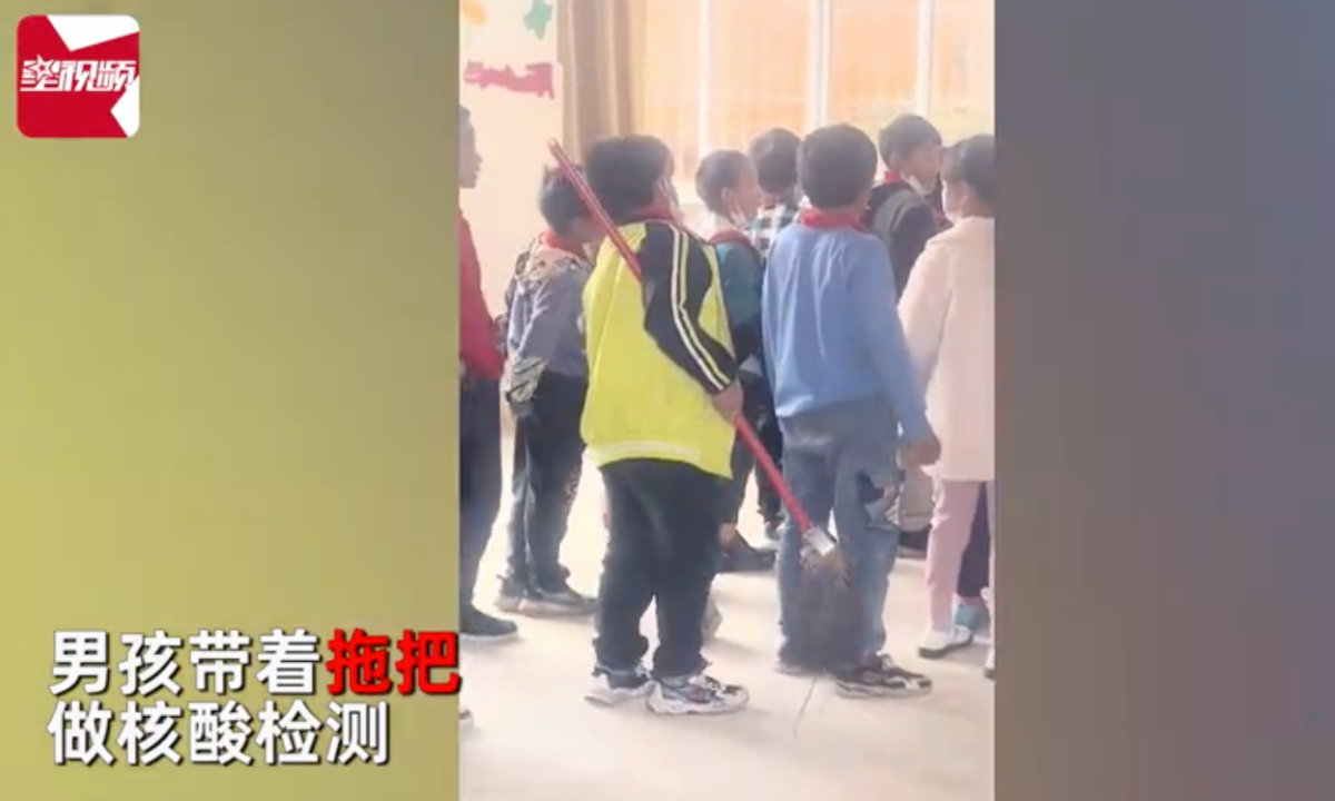 The boy from Southwest China's Yunnan Province carrying a mop for a nucleic acid test. Screenshot of Star Video