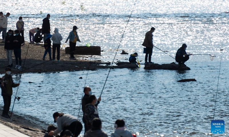 Tourists have fun along the Songhua River in Harbin, northeast China's Heilongjiang Province, May 14, 2022. Outdoor scenic spots in Harbin have resumed operations under strict COVID-19 prevention measures recently. (Xinhua/Xie Jianfei)