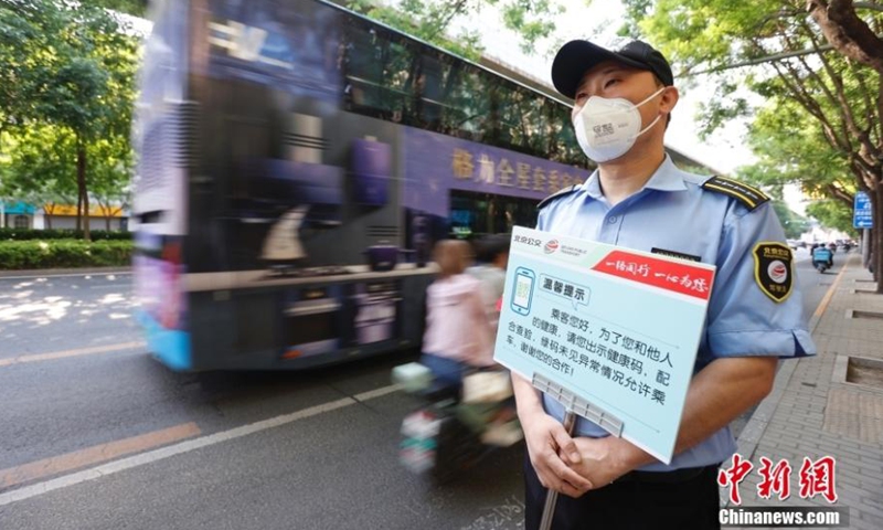 A staff member holds a placard to remind passengers to show their health codes at a bus station in Beijing, May 17, 2022. (Photo: China News Service/Han Haidan)

Starting Tuesday, passengers should show their green health codes before boarding buses and entering subway stations around the locked-down and controlled zones in Beijing. These measures involve 190 bus lines and 54 subway stations.