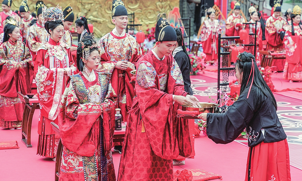 Couples dressed in traditional Chinese wedding attire hold a mass wedding in Nanning, South China's Guangxi Zhuang Autonomous Region on May 20, 2022. The 520 translates to 