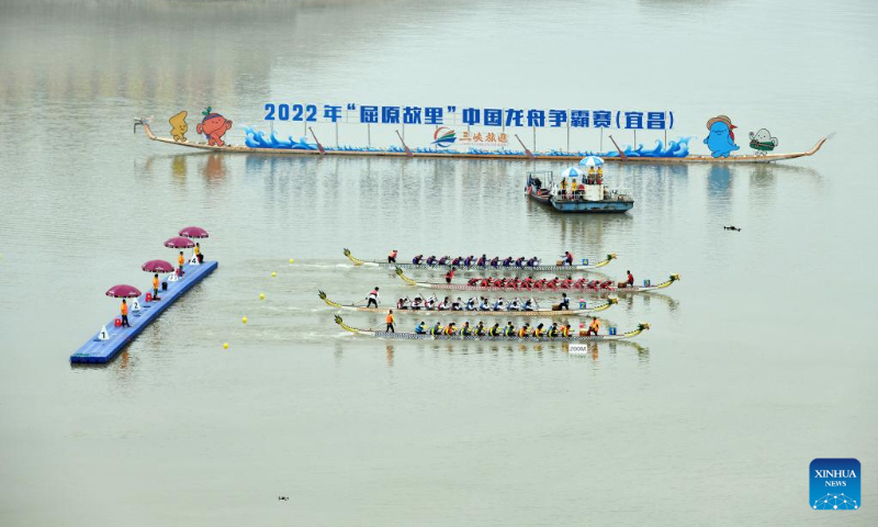 Dragon boat crew members compete in a traditional Chinese dragon boat race in Zigui County, central China's Hubei Province, June 3, 2022. Over 400 participants competed in a dragon boat race here with the backdrop of the Three Gorges Dam to celebrate China's traditional Dragon Boat Festival. (Photo by Wang Huifu/Xinhua)