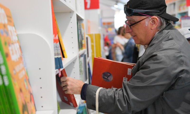 A man selects books at the annual book festival on the Red Square in Moscow, Russia, on June 3, 2022. (Photo by Alexander Zemlianichenko Jr/Xinhua)