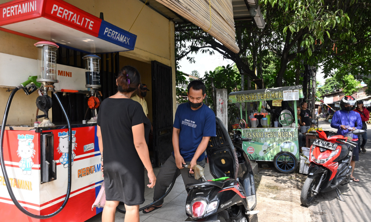 An attendant fills petrol into a motorcycle at a gas station in Jakarta on May 29, 2022. Indonesia’s parliament in May approved a request to increase energy subsidies because of rising commodity prices. Photo: AFP