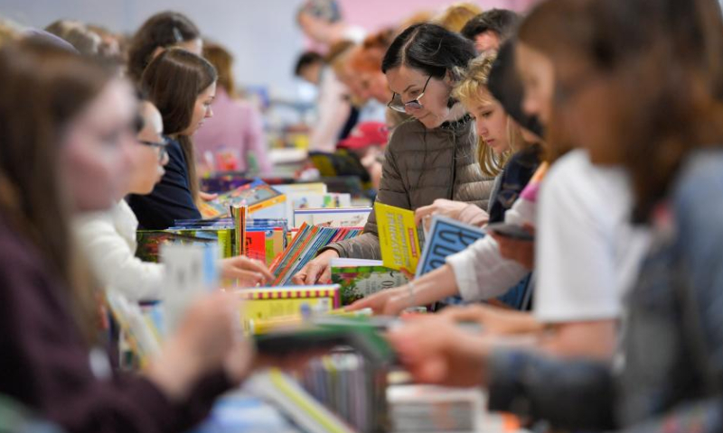 People select books at the annual book festival on the Red Square in Moscow, Russia, on June 3, 2022. (Photo by Alexander Zemlianichenko Jr/Xinhua)