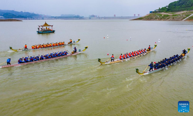 Aerial photo taken on June 3, 2022 shows dragon boat crew members competing in a traditional Chinese dragon boat race in Zigui County, central China's Hubei Province. Over 400 participants competed in a dragon boat race here with the backdrop of the Three Gorges Dam to celebrate China's traditional Dragon Boat Festival. (Photo by Nie Shuang/Xinhua)