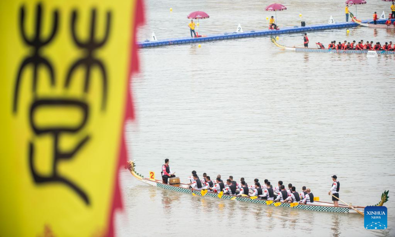 Dragon boat crew members prepare to compete in a traditional Chinese dragon boat race in Zigui County, central China's Hubei Province, June 3, 2022. Over 400 participants competed in a dragon boat race here with the backdrop of the Three Gorges Dam to celebrate China's traditional Dragon Boat Festival. (Photo by Wu Zhizun/Xinhua)