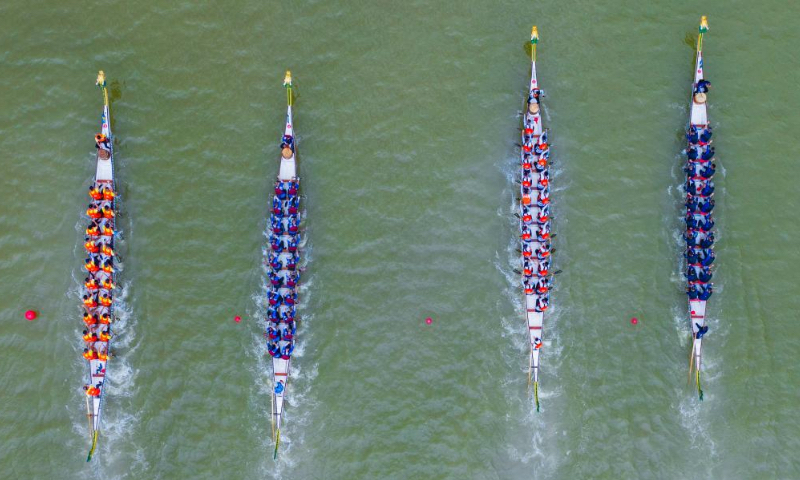 Aerial photo taken on June 3, 2022 shows dragon boat crew members competing in a traditional Chinese dragon boat race in Zigui County, central China's Hubei Province. Over 400 participants competed in a dragon boat race here with the backdrop of the Three Gorges Dam to celebrate China's traditional Dragon Boat Festival. (Photo by Nie Shuang/Xinhua)