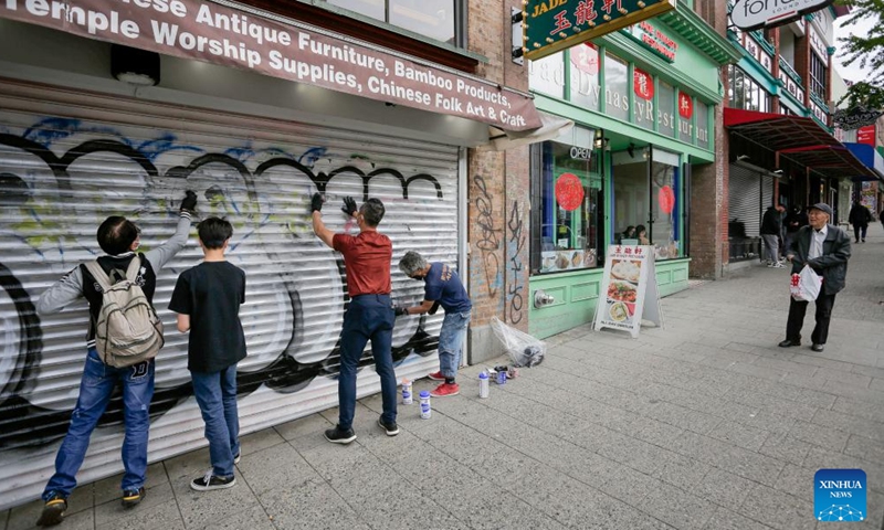 Volunteers cover up graffiti on a wall in Chinatown of Vancouver, British Columbia, Canada, on May 28, 2022.Photo:Xinhua