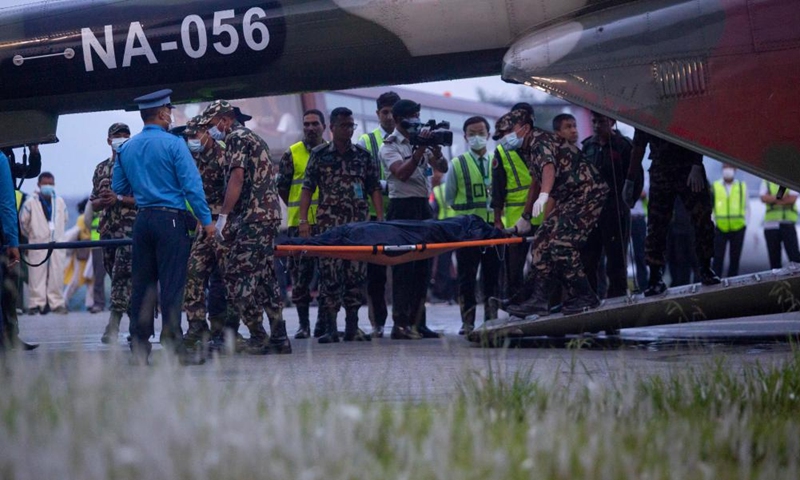 A rescue team of Nepal Army carry the body of a plane crash victim at the airport in Kathmandu, Nepal, May 30, 2022. Twenty-one bodies have been recovered from the crash site of a Nepali passenger plane in a remote hilly area in Nepal's Mustang district, a local government official said on Monday. Ten bodies have been sent to Kathmandu in a helicopter, the official said.(Photo: Xinhua)