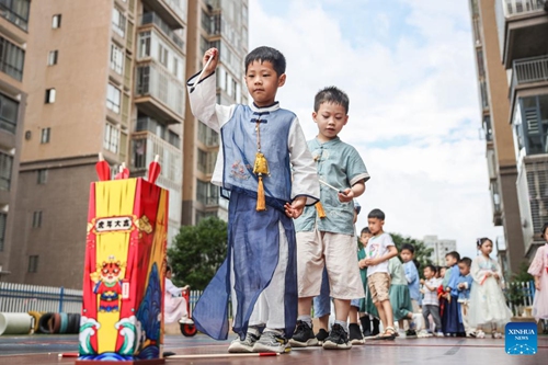 Children take part in Touhu game, or Pitch-pot, an ancient entertainment that requires players to throw arrows from a set distance into a tube, on the eve of the Dragon Boat Festival at a kindergarten in Lanshan County of Yongzhou City, central China's Hunan Province, June 2, 2022. The Dragon Boat Festival will fall on June 3 this year. (Photo by Peng Hua/Xinhua)
