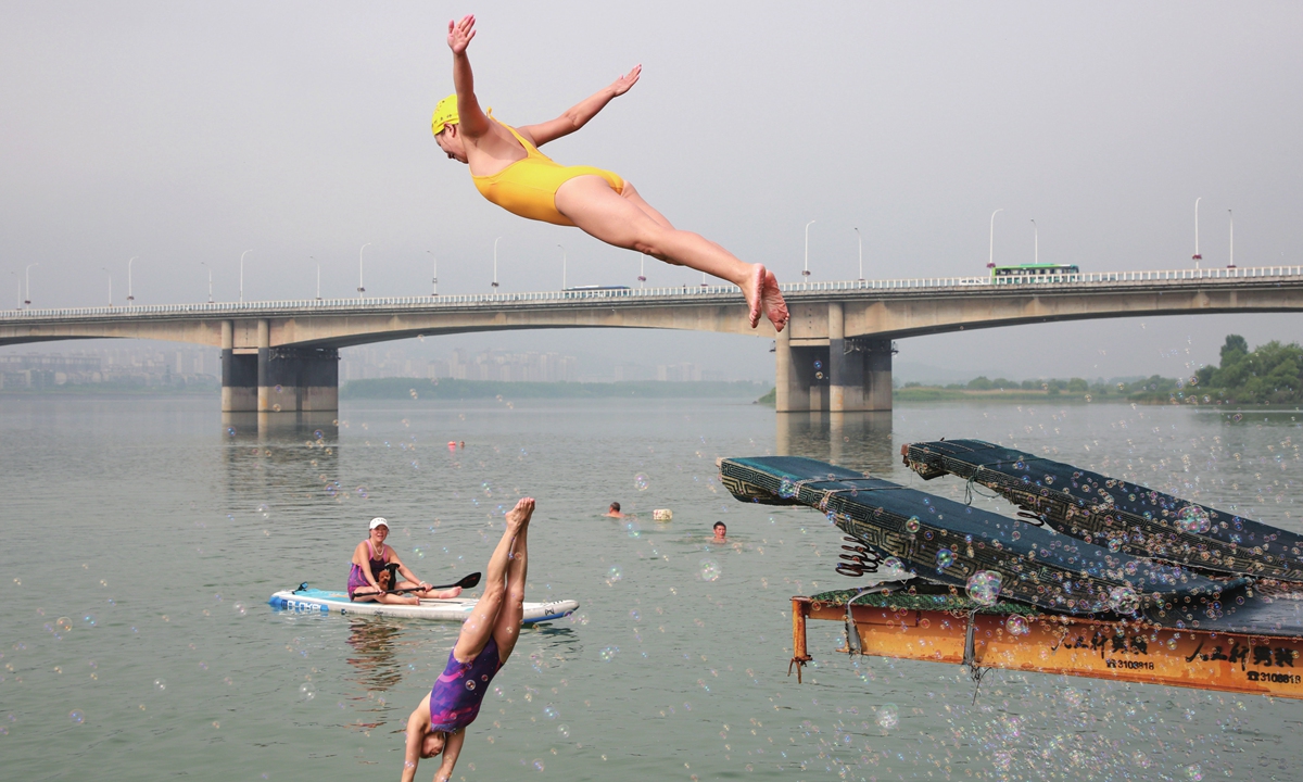 Swimmers take part in a fancy diving event at the Han River in Xiangyang, Central China's Hubei Province, on June 3, 2022. Photo: IC