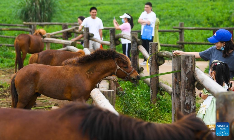 Tourists visit Guangyang Isle in southwest China's Chongqing, June 5, 2022. Guangyang Isle, the largest island on the upper Yangtze River, is rich in natural resources. In recent years, a series of measures have been taken to restore the island's ecological environment, attracting tourists to its colorful fields.(Photo: Xinhua)