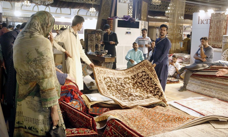 Vendors show a carpet to visitors during a furniture and lifestyle expo in Rawalpindi, Pakistan on June 10, 2022.(Photo: Xinhua)