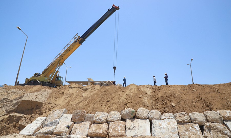 Palestinian engineers and workers use cranes to place concrete blocks to prevent coastal erosion, in Gaza City, on June 9, 2022.(Photo: Xinhua)