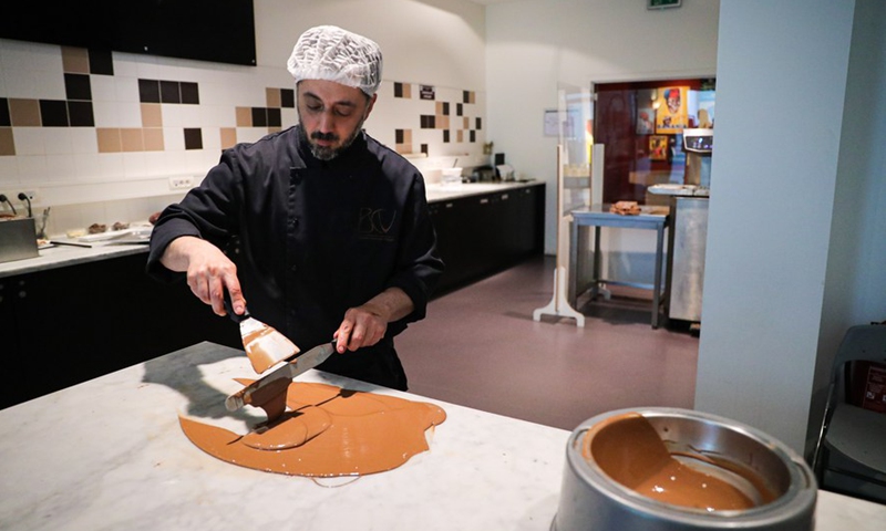 A staff member shows the making of chocolate in the Belgian Chocolate Village in Brussels, Belgium, June 9, 2022.Photo:Xinhua