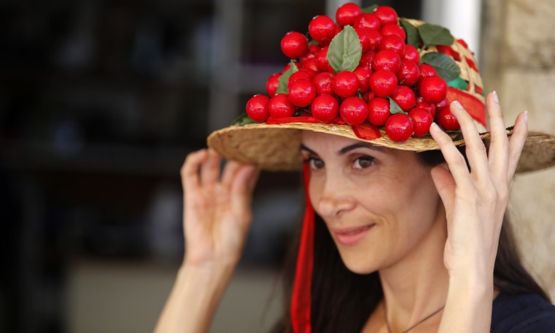 A woman shows a cherry hat at the Hammana Cherry Festival in the village of Hammana, Mount Lebanon Governorate, Lebanon, on June 12, 2022.(Photo: Xinhua)