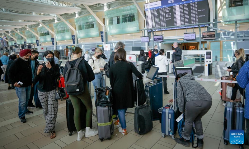 Travelers line up to check in at Vancouver International Airport in Richmond, British Columbia, Canada, on June 14, 2022. The Canadian federal government announced Tuesday that it will suspend vaccination requirements against COVID-19 for domestic and outbound travel, federally regulated transportation sectors and federal government employees as of June 20.(Photo: Xinhua)