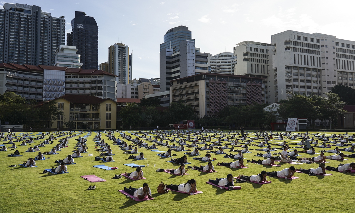 Hundreds of people participate in a yoga exercise at Srinakharinwirot University field, marking the International Day of Yoga in Bangkok, Thailand on June 19, 2022. Photo: VCG