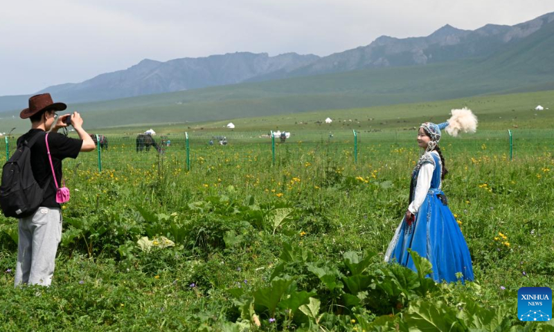 Visitors take photos at the Narat scenic spot in Xinyuan County, northwest China's Xinjiang Uygur Autonomous Region, June 28, 2022. (Xinhua/Hao Jianwei)