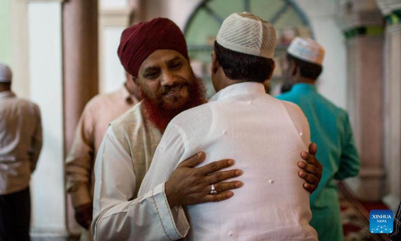 People greet each other during Eid al-Adha in a mosque in Kathmandu, Nepal, July 10, 2022. (Photo by Sulav Shrestha/Xinhua)