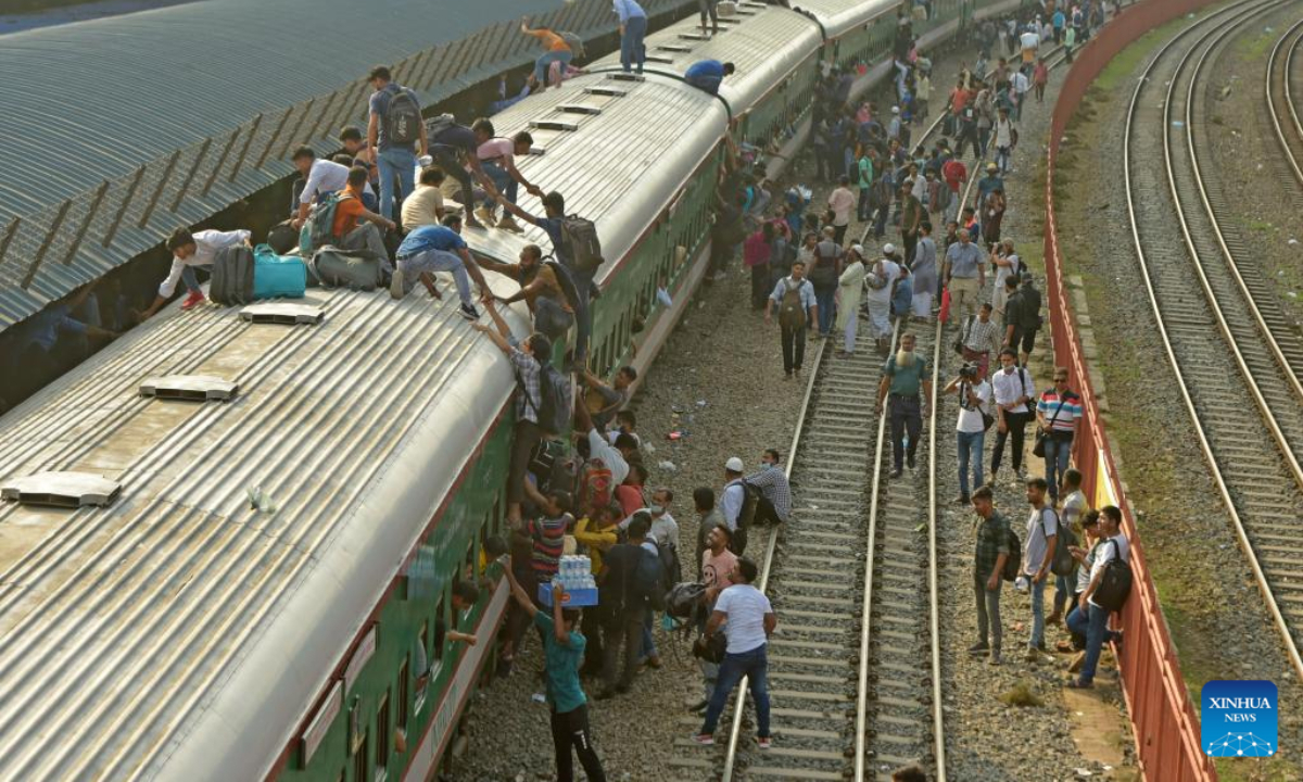 Travelers try to climb up a train at a railway station in Dhaka, Bangladesh, July 7, 2022. As Eid al-Adha festival approaches, many people from Bangladesh capital Dhaka have streamed out of the city to join the festival with their kith and kin in village homes. Photo:Xinhua