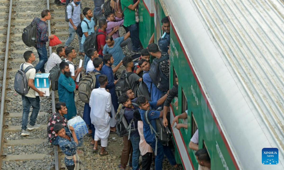 Travelers try to climb up a train at a railway station in Dhaka, Bangladesh, July 7, 2022. As Eid al-Adha festival approaches, many people from Bangladesh capital Dhaka have streamed out of the city to join the festival with their kith and kin in village homes. Photo:Xinhua