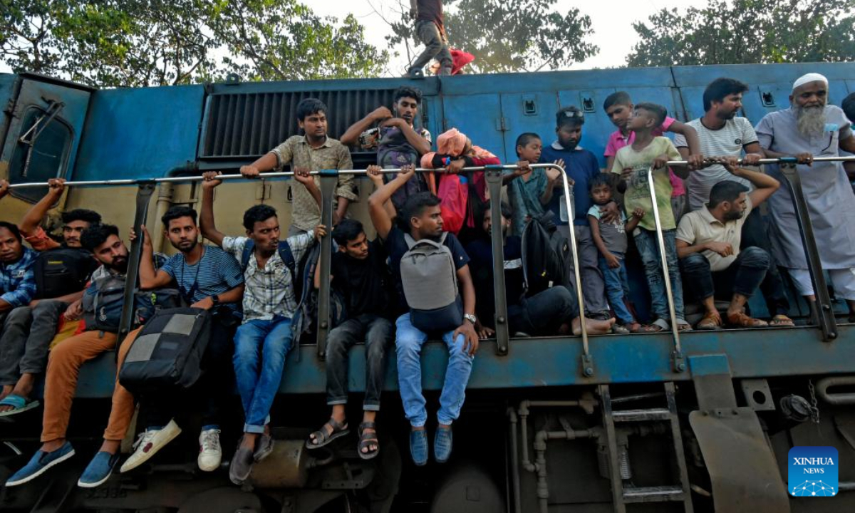 People cling to train carriages as they head to their homes to celebrate Eid al-Adha festival, from Dhaka, Bangladesh, July 7, 2022. As Eid al-Adha festival approaches, many people from Bangladesh capital Dhaka have streamed out of the city to join the festival with their kith and kin in village homes. Photo:Xinhua