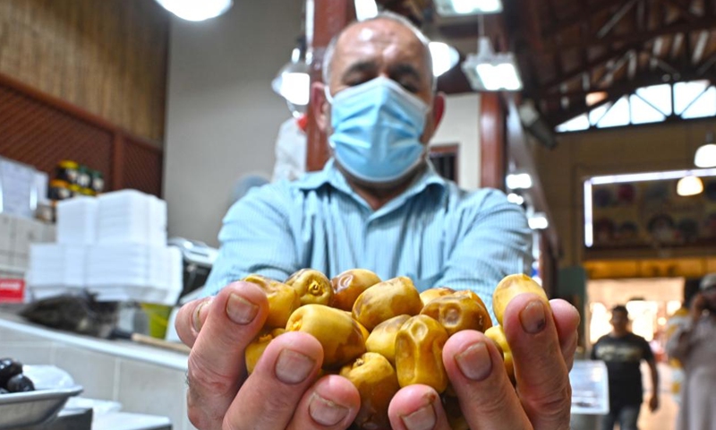 Photo taken on July 2, 2022 shows a seller displaying dates in the old market in Kuwait City, Kuwait.Photo:Xinhua